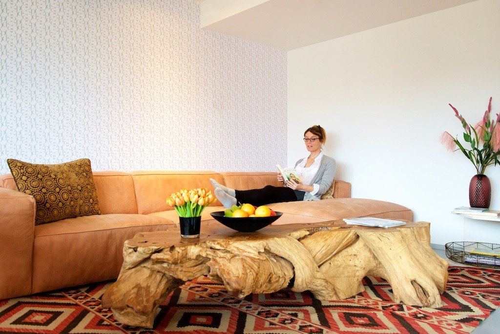 Een vrouw ontspant in de woonkamer van het gastenverblijf of guesthouse in o2 Clinic.